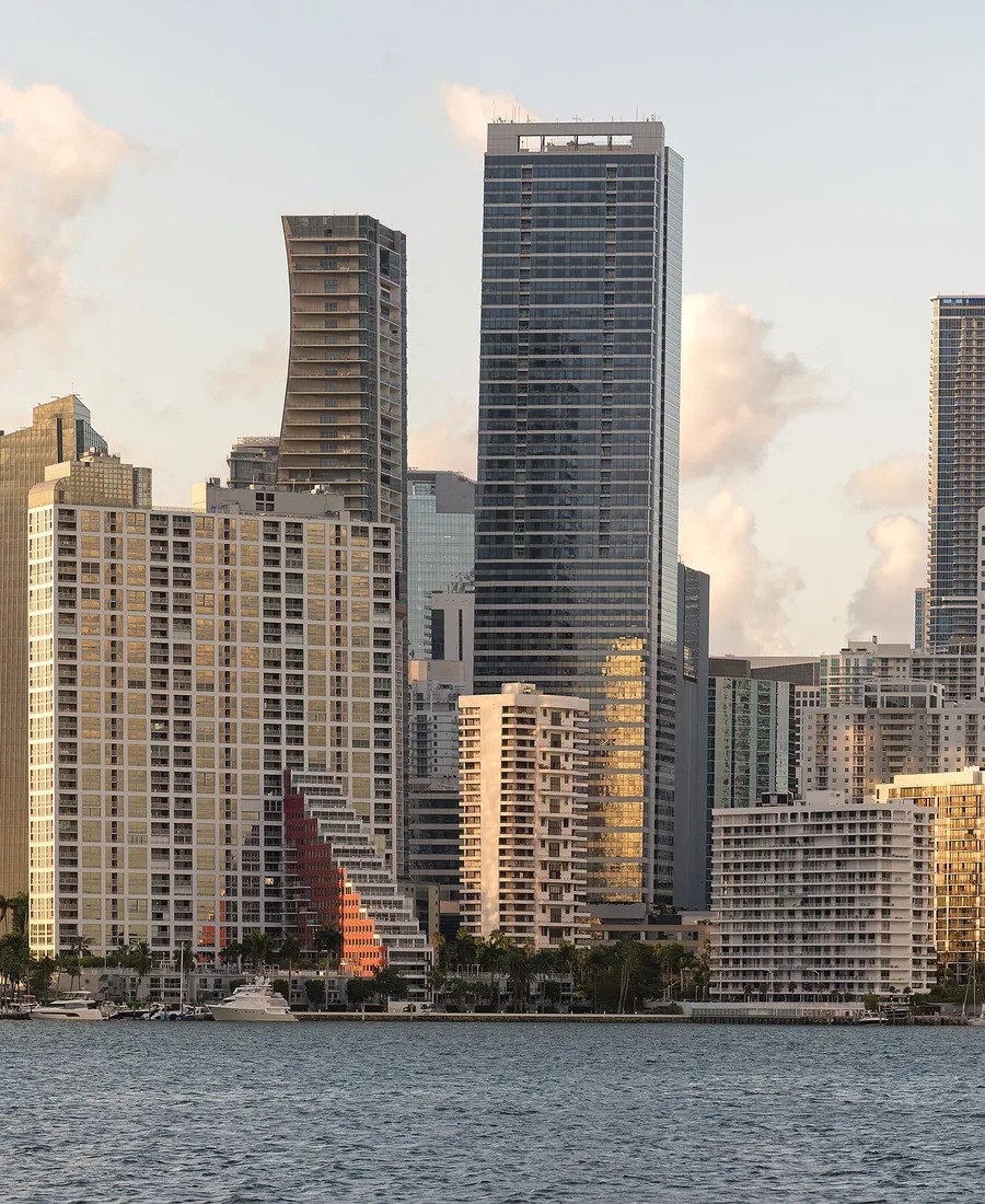 The Miami skyline rising above Biscayne Bay in warm evening light